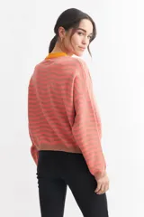 Sweater de punto a rayas horizontales verdes y blancas con cuello redondo en color coral.