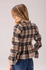 Blusa de manga larga con estampado a cuadros en tonos beige y negro, cuello alto con volados, diseño fruncido en el pecho y las mangas, y terminación acampanada en los puños y el bajo.