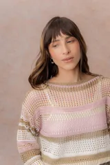 Buzo tejido de punto calado con rayas horizontales multicolor en tonos azul, amarillo, celeste y blanco, con escote bote, mangas largas y hombros caídos. Incluye top básico al tono.