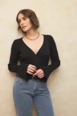 Sweater negro de tejido de punto con escote cruzado en V y mangas largas acampanadas.