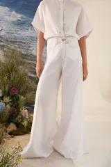 Pantalón de lino blanco de corte wide leg, con diseño amplio y costuras pespunteadas a contratono.