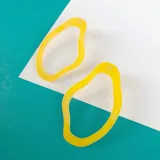 Par de aros colgantes de acrílico amarillo con forma orgánica irregular.