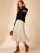 Suéter de punto negro con cuello redondo y bordados florales en hilo dorado en ambas mangas.