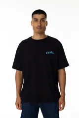 Remera negra de algodón con estampa trasera de un surfista plateado sobre una tabla en el espacio. Logo VERNAL frontal con acabado galáctico.