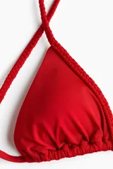 Top de bikini triangular rojo con copas con relleno extraíble, tirantes trenzados y tiras para anudar en la espalda.