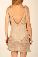 Vestido corto beige de hilo con diseño calado y sin mangas.