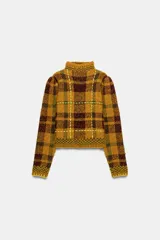 Jersey de punto con cuello perkins y manga larga, diseño a cuadros en tonos mostaza y marrón con detalles de costuras en color amarillo neón.