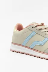 Zapatilla de estilo urbano con paneles de gamuza en tonos beige y gris, detalles en celeste y rosado. Cuenta con suela dentada de goma y cierre mediante cordones.