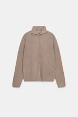 Chaqueta de punto confeccionada en lana, con cuello subido, manga larga y cierre frontal con botones. Presenta un acabado con efecto cepillado.