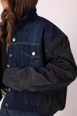 Campera corta de denim azul con mangas largas abullonadas de tela sintética negra.