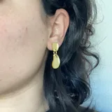 Par de aros colgantes con base rectangular plateada y dije irregular con efecto marmolado en tonos grises.