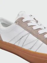 Championes Moncler modelo Monaco, de color blanco con detalles en gamuza gris en los ojales y talón, y suela de goma marrón translúcida.