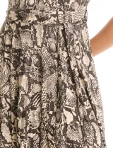 Vestido midi de seda fría con estampado animal print. Presenta cuello con solapa, escote en V con cierre frontal de botones, mangas cortas con terminación fruncida y lazo de ajuste en la cintura.