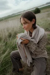 Camisa de manga larga con estampado cuadrillé en tonos marrones y negros, cuello alto con volados y puños elásticos.