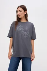 Remera de algodón lavado con textura suave, de calce clásico y manga corta. Presenta un bordado lineal de flores a tono en la parte frontal.