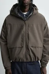 Cazadora relaxed fit de tejido técnico repelente al agua, con interior forrado en tejido polar. Presenta capucha ajustable, cierre frontal con cremallera, bolsillos con cierre en pecho y cadera, y puños y bajo con elástico.