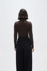 Polera de poliamida ajustada al cuerpo, con cuello alto y mangas largas.