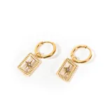 Aros dorados de acero enchapado en oro, con forma de argolla y dije rectangular con diseño de estrella de ocho puntas y un cristal en el centro.