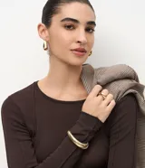 Suéter de punto color azul vibrante, con corte ajustado, cuello redondo y mangas largas. Presenta detalles de nervaduras verticales a lo largo de la prenda que estilizan la silueta.