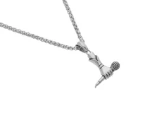 Collar plateado con dije en forma de mano sosteniendo un micrófono.