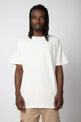 Remera de corte oversize, color blanco, con cuello redondo y mangas cortas, confeccionada en algodón.