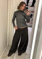 Jean de corte wide leg en color negro lavado, con costuras verticales marcadas y terminación en el bajo con puño holgado tipo babucha.