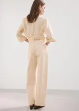 Jeans tiro medio color beige, de corte recto y holgado, con diseño clásico de cinco bolsillos y trabillas para cinturón.