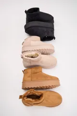 Bota corta estilo australiano en color negro, con plataforma plana y forro interior suave.