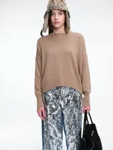 Sweater de punto color tostado, con cuello redondo, hombro caído y mangas largas con puños acanalados. Presenta un diseño de calce relajado con terminación acanalada en el ruedo.