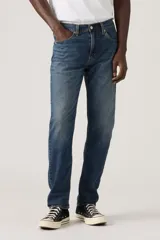 Pantalón de jean corte regular taper, con diseño de cinco bolsillos, cierre de botón y cremallera, y acabado en tono azul medio con efecto desgastado.