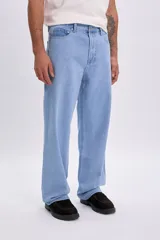 Pantalón jean de corte holgado y tiro medio, en color azul claro, con diseño clásico de cinco bolsillos y pespuntes en contraste.