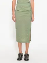 Pollera midi verde de lycra de gasa con hotfix dorados, tajo lateral y frunce.