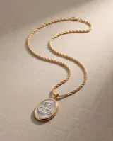 Collar de cadena de eslabones con baño de oro y dije ovalado colgante con relieve de San Benito en tono plateado y borde dorado.