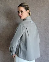 Sobrecamisa de denim azul con cuello camisero, cierre frontal con botones, mangas largas con puños abotonados y dos bolsillos con solapa en el pecho.