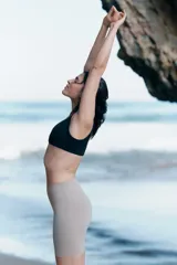 Top deportivo negro para yoga, de tejido funcional con efecto segunda piel y alta elasticidad gracias a la tecnología Lycra® Sport. Diseño con breteles anchos, escote en V profundo y detalle cruzado/girado en el frente. Incluye copas forradas con relleno extraíble.