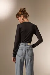 Body de manga larga con cuello a la base, confeccionado en poliamida, con ajuste al cuerpo y cierre inferior con broches.