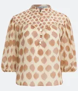 Camisa de gasa color beige con estampado de lunares marrones, cuello mao, mangas 3/4 abullonadas y cierre frontal con botones.