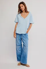 Remera de algodón celeste, de corte oversize con escote en V amplio y mangas cortas caídas.