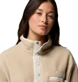 Polar Columbia modelo Helvetia II Cropped, color beige, confeccionado en tejido de corderito suave con cuello alto y cierre frontal de botones a presión. Cuenta con un bolsillo con cierre en el pecho con tirador y puños elásticos.