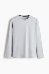 Remera deportiva de manga larga con cuello redondo, confeccionada en tejido funcional transpirable con tecnología DryMove que absorbe el sudor. Presenta un diseño liso con aberturas laterales en el bajo y corte estándar.
