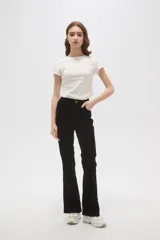 Pantalon de corte flare y tiro alto, confeccionado en tejido de algodón con textura aterciopelada, de color negro.