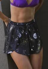 Short negro de satén estampado con lunas, estrellas y galaxias. Tiene cintura elastizada, cordones para ajustar y tiro alto.