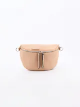 Riñonera o cangurera de cuero sintético color beige, con forma curva y cierre doble frontal. Presenta tiradores largos en las cremalleras y argollas metálicas laterales para sujetar la correa.