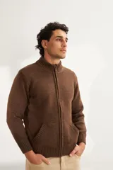 Campera marrón tejida con cierre delantero, cuello alto y bolsillos delanteros. Tejida en 100% lana fina sin teñir.