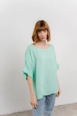 Blusa de lino color menta, de corte amplio y relajado, con escote redondo y mangas 3/4 remangadas.