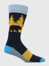 Calcetín de largo medio con diseño estampado de un oso y árboles en color amarillo sobre fondo azul marino. Presenta detalles en celeste en el puño, talón y puntera, y una franja gris y amarilla en la planta.