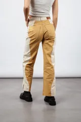 Pantalón de jean color mostaza con paneles laterales color crema, de corte recto y tiro medio.