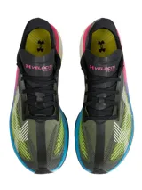 Championes de running Under Armour Velociti Elite 3, diseñados para carreras de larga distancia. Presentan una parte superior de tejido elástico en tonos oscuros con detalles en amarillo neón y blanco. La entresuela destaca por su diseño multicolor con capas en rosa, amarillo y azul, sobre una base blanca, incorporando placa de fibra de carbono para mayor retorno de energía.
