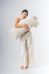 Pantalón de algodón color crudo con rayas verticales finas en beige, corte recto, cintura con elástico y detalle de puntilla en cintura y ruedo.