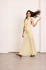 Falda larga color amarillo pálido de microtul, con diseño fruncido en la parte superior y acabado fluido en el bajo.